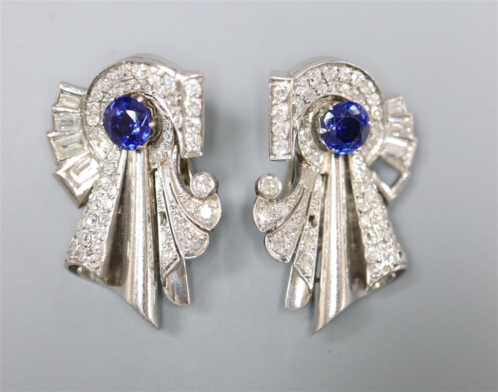 A pair of diamond and sapphire clips in white metal settings (tests as platinum), white metal fitments (three diamonds missing),